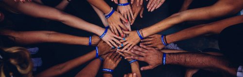 Group of hands reaching in to the centre